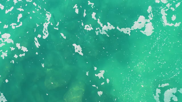 LAGUNA BEACH LOS CABOS BCS MEXICO-2021: Overhead View of Turquoise Water with Moving Foam Patches