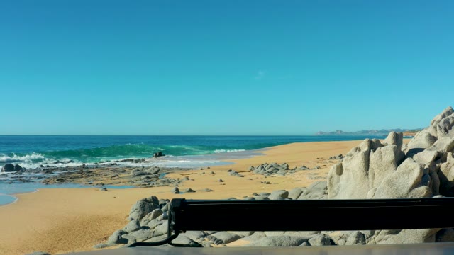 LAGUNA BEACH LOS CABOS BCS MEXICO-2021: Waves Crashing on Sandy Beach with Rocky Outcrops