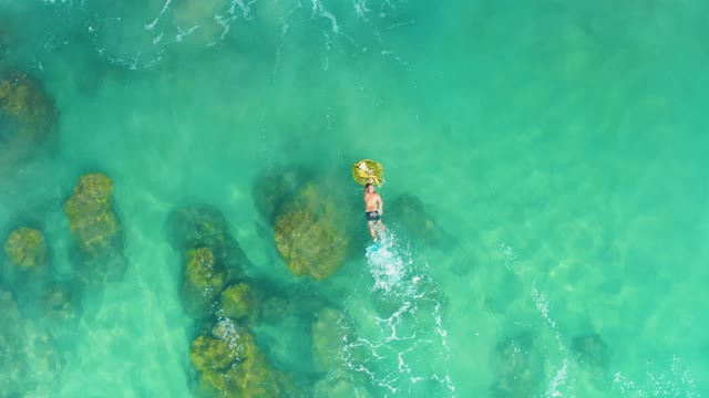 LAGUNA BEACH LOS CABOS BCS MEXICO-2021: Person Floating on a Yellow Ring in Shallow Turquoise Water