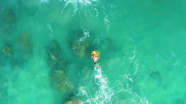 LAGUNA BEACH LOS CABOS BCS MEXICO-2021: Person Floating on Inflatable Ring in Clear Turquoise Water