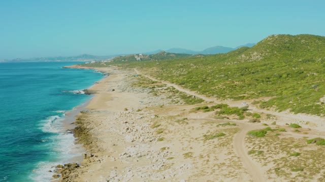 LAGUNA BEACH LOS CABOS BCS MEXICO-2021: Gentle Ocean Waves Lapping Sandy Coast with Green Hills