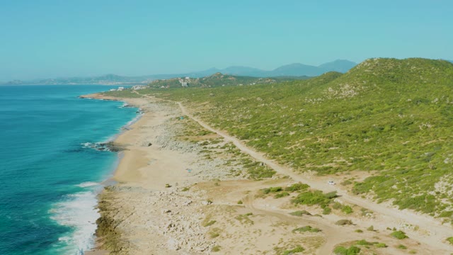 LAGUNA BEACH LOS CABOS BCS MEXICO-2021: Vehicle Driving Along Coastal Road by Sandy Beach