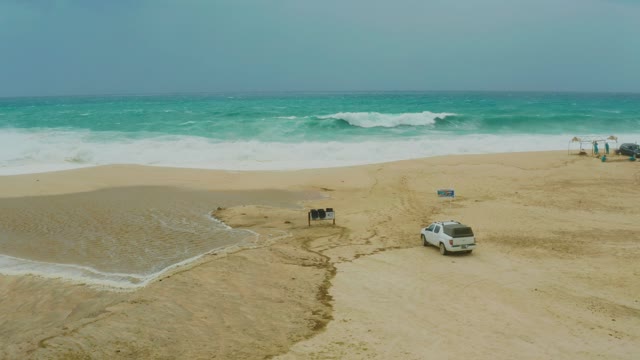DREAMS RESORT LOS CABOS BCS MEXICO-2021: SUV Driving on Sandy Beach near Ocean Waves