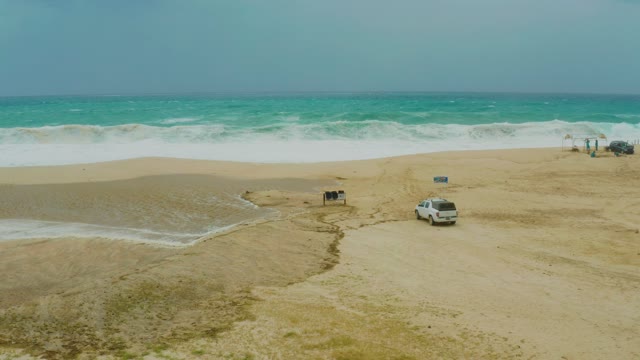 DREAMS RESORT LOS CABOS BCS MEXICO-2021: Waves Crashing on Sandy Beach with Parked Vehicle