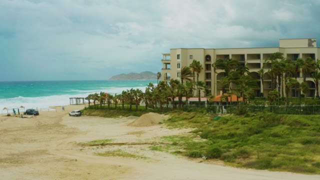 DREAMS RESORT LOS CABOS BCS MEXICO-2021: Person Walking Along Beach near Coastal Building