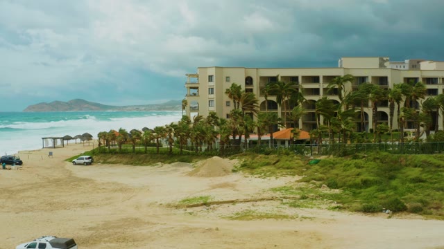 DREAMS RESORT LOS CABOS BCS MEXICO-2021: Car Driving on Sandy Beach Near Resort Building