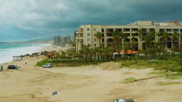 DREAMS RESORT LOS CABOS BCS MEXICO-2021: Sandy Beach and Hotel by the Ocean with Cloudy Sky