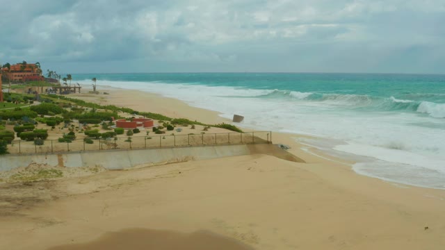 DREAMS RESORT LOS CABOS BCS MEXICO-2021: Waves Crashing on Sandy Beach with Coastal Greenery