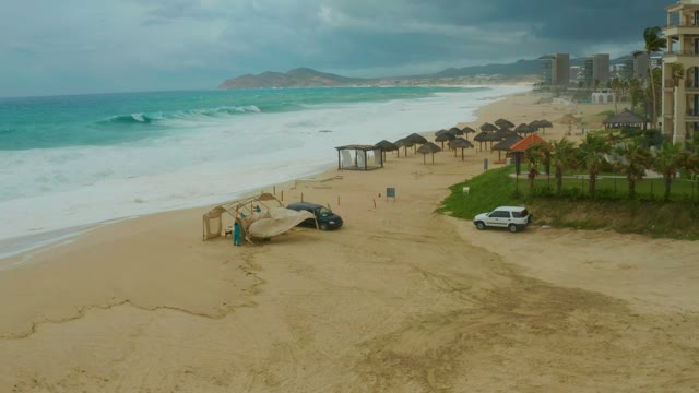 DREAMS RESORT LOS CABOS BCS MEXICO-2021: Waves Crashing on Sandy Beach Under Overcast Sky