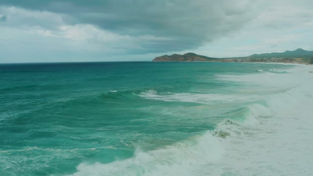 DREAMS RESORT LOS CABOS BCS MEXICO-2021: Waves Crashing Onto Sandy Beach Under Cloudy Sky