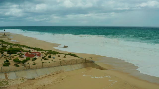 DREAMS RESORT LOS CABOS BCS MEXICO-2021: Ocean Waves Receding From Sandy Shore Under Cloudy Sky