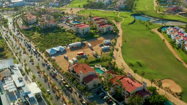 SAN JOSE DEL CABO BCS MEXICO-2021: Traffic Flowing on Road Near Golf Course and Buildings