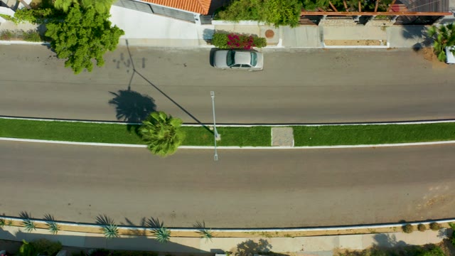 SAN JOSE DEL CABO BCS MEXICO-2021: Overhead View of a White Car Driving Left on a Street