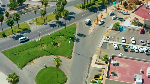SAN JOSE DEL CABO BCS MEXICO-2021: Vehicles Moving at a Palm Tree Lined Street Intersection