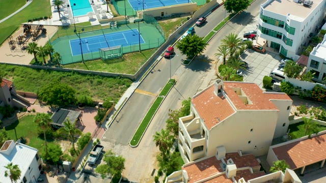 SAN JOSE DEL CABO BCS MEXICO-2021: Vehicles Moving on Road near Tennis Courts and Homes