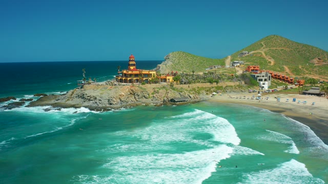 CERRITOS BEACH BCS MEXICO-2021: Lighthouse on Rocky Coast with Ocean Waves