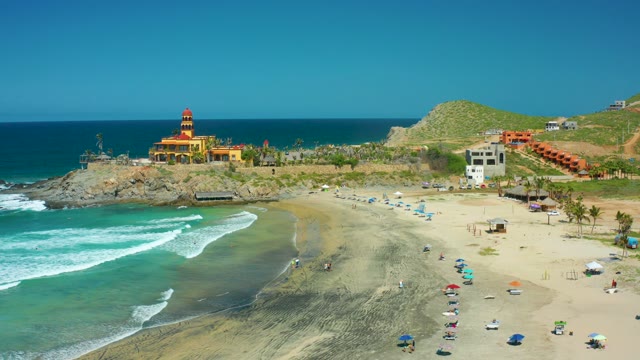 CERRITOS BEACH BCS MEXICO-2021: Lighthouse on Rocky Shore with Beachgoers and Ocean Waves