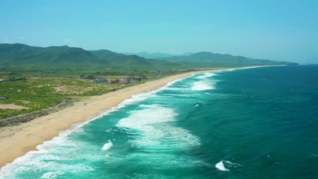 CERRITOS BEACH BCS MEXICO-2021: Waves Rolling Onto Sandy Beach with Mountain Range