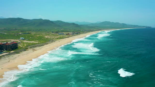 CERRITOS BEACH BCS MEXICO-2021: Gentle Ocean Waves Rolling Onto Sandy Beach with Hills