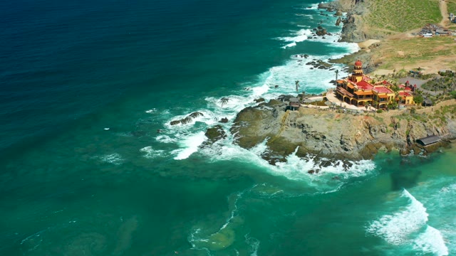 CERRITOS BEACH BCS MEXICO-2021: Waves Crashing on Rocky Coast with Cliffside Building