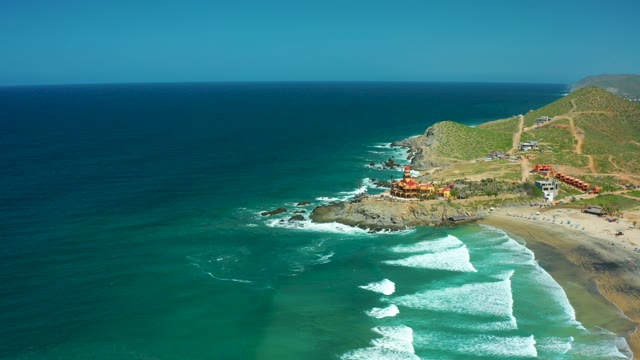 CERRITOS BEACH BCS MEXICO-2021: Waves Rolling Toward Sandy Beach with Cliffside Buildings