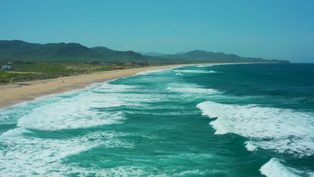 CERRITOS BEACH BCS MEXICO-2021: Waves Crashing Onto Sandy Shore with Distant Hills