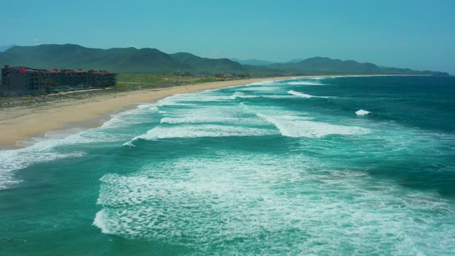 CERRITOS BEACH BCS MEXICO-2021: Waves Crashing on Sandy Shore with Distant Mountains