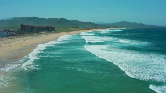 CERRITOS BEACH BCS MEXICO-2021: Waves Rolling Onto Sandy Beach with Coastal Buildings