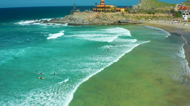 CERRITOS BEACH BCS MEXICO-2021: Beachgoers in Ocean Waves Near Rocky Headland