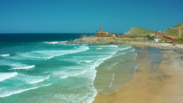 CERRITOS BEACH BCS MEXICO-2021: Waves Rolling Onto Sandy Shore with Lighthouse