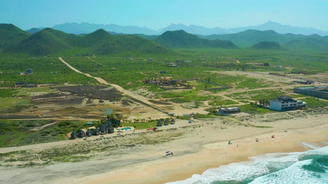 CERRITOS BEACH BCS MEXICO-2021: Beachside Road with Car Moving Past Green Hills