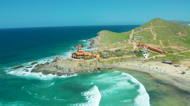 CERRITOS BEACH BCS MEXICO-2021: Waves Crashing on Rocky Shore with Coastal Buildings