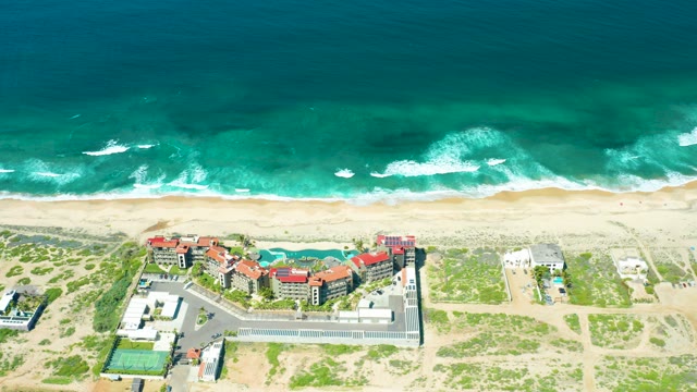 CERRITOS BEACH BCS MEXICO-2021: Waves Rolling Toward Sandy Shore with Coastal Buildings