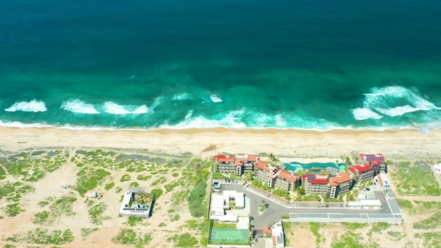 CERRITOS BEACH BCS MEXICO-2021: Waves Advancing Toward Sandy Beach with Coastal Buildings