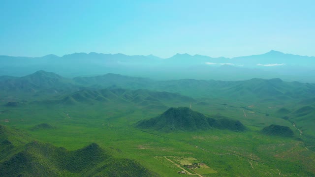 CERRITOS BEACH BCS MEXICO-2021: Aerial Pan of Lush Green Hills and Distant Mountains
