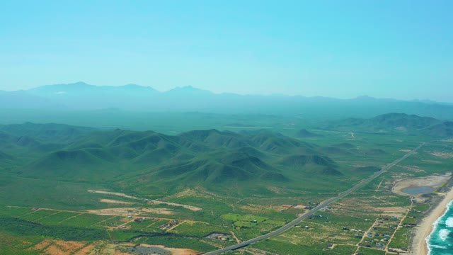 CERRITOS BEACH BCS MEXICO-2021: Vehicle Traveling Along Coastal Road with Mountainous Landscape