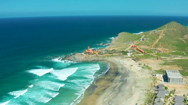 CERRITOS BEACH BCS MEXICO-2021: Waves Crashing on a Sandy Coastline with Hillside Buildings