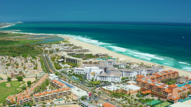 SAN JOSE DEL CABO BCS MEXICO-2021: Vehicles Moving on Coastal Road Near Beachfront Buildings