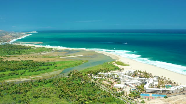 SAN JOSE DEL CABO BCS MEXICO-2021: Boat Moving Along Ocean Coastline with Beach and River