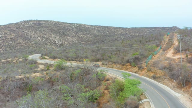 LA PLAYITA LOS CABOS MEXICO-2021: Vehicle Traveling on Winding Road Through Arid Hills