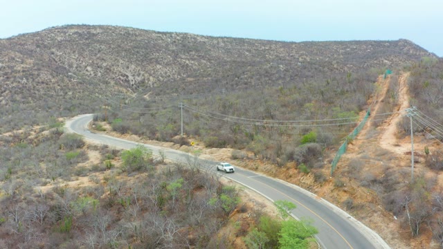 LA PLAYITA LOS CABOS MEXICO-2021: Vehicles Moving Along a Winding Hilly Road