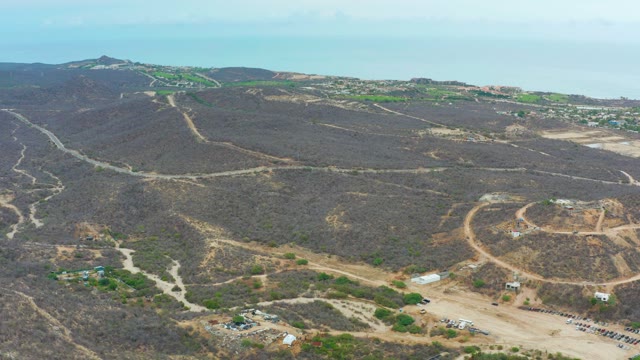 LA PLAYITA LOS CABOS MEXICO-2021: Hilly Terrain with Dirt Roads and Ocean in Background