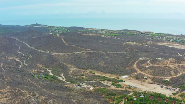 LA PLAYITA LOS CABOS MEXICO-2021: Hilly Landscape with Moving Vehicle and Sparse Greenery