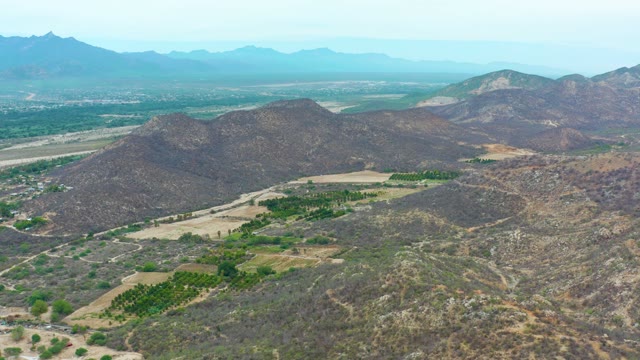 LA PLAYITA LOS CABOS MEXICO-2021: Aerial Pan of Mountain Valley and Green Fields