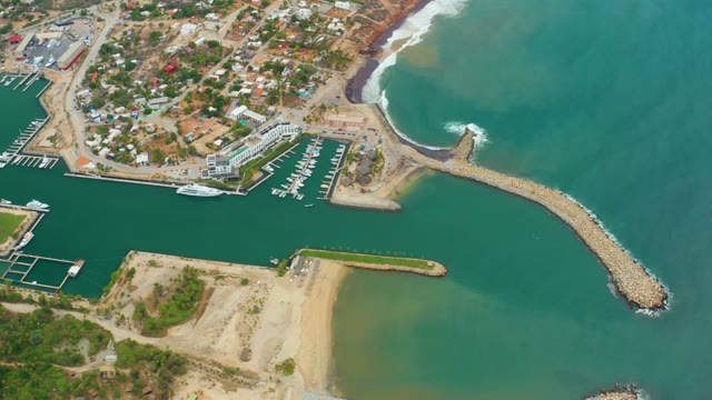 LA PLAYITA LOS CABOS MEXICO-2021: Ocean Waves Crashing Against Coastal Breakwater and Marina