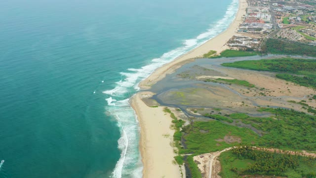 LA PLAYITA LOS CABOS MEXICO-2021: Waves Rolling Onto Sandy Beach with Coastal Vegetation