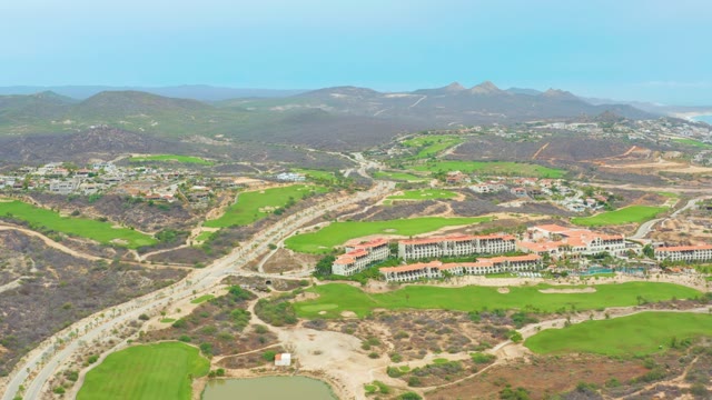 LA PLAYITA LOS CABOS MEXICO-2021: Golf Course and Highway with Mountain Backdrop Aerial View