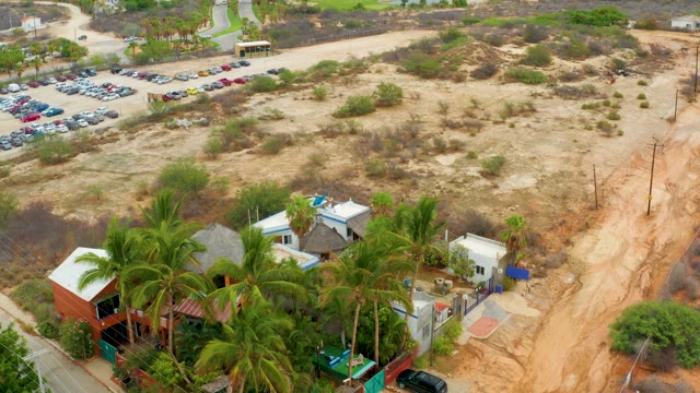 LA PLAYITA LOS CABOS MEXICO-2021: Vehicles Moving in Parking Lot and Sandy Road
