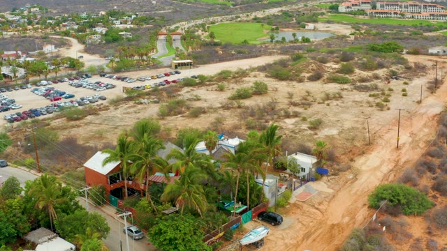 LA PLAYITA LOS CABOS MEXICO-2021: Aerial Pan of Arid Area with Parking Lot and Buildings