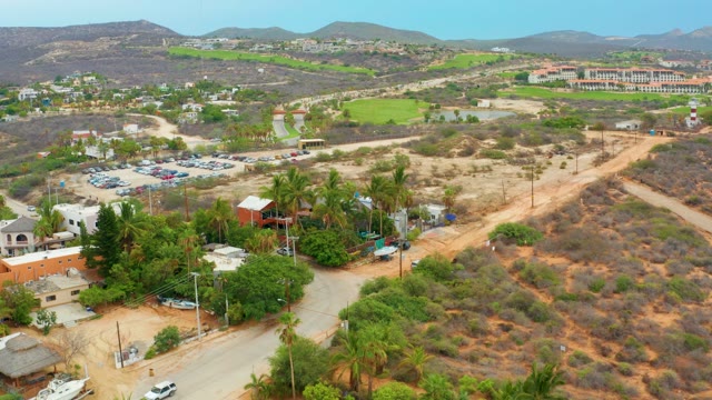 LA PLAYITA LOS CABOS MEXICO-2021: Vehicles on Road Through Arid Landscape with Hills